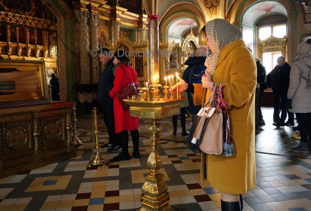 MOSCOW... A woman lights a candle in a monastery in Sergiev Posad...