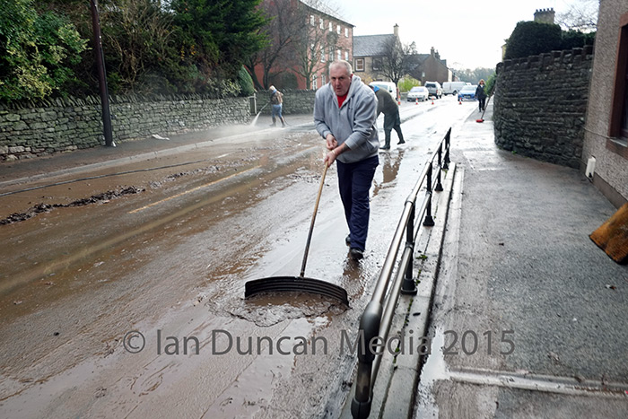 CLEAN UP... Villagers from Eamont Bridge and the surrounding area rally round to clear up the mess left behind by the weekend's flood which residents said was worse than the one in 2009...