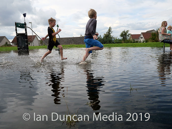 POOL... Youngsters splashing through the flooded playground in Milton of Leys after torrential rain hit the Highlands during the early hours of Wednesday morning...