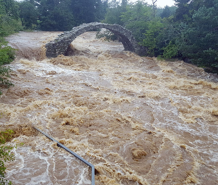 DELUGE... The historic pack horse bridge at Carrbridge was under a huge amount of pressure from flooding on the river Dulnain with the water level unto the viewing platform... Picture: Lee Schofield @highlandweather 
