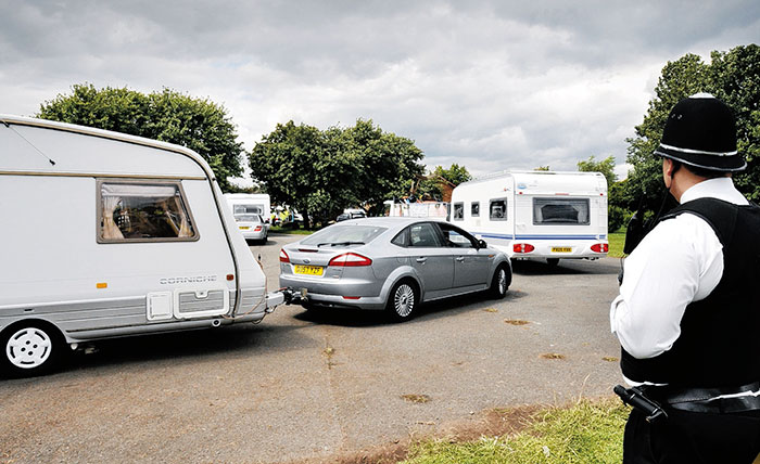 EVICTION... An officer watches the last of the traveller convoys leave Burniston Road car park...