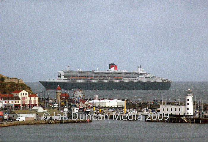 SPECTACULAR SIGHT... The Queen Mary 2, about to vanish behind the castle headland as it makes its way up the coast yesterday...