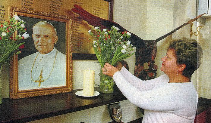 FLOWERS... Polish Social Centre steward Mariola Grant arranges a floral display dedicated to Pope John Paul...