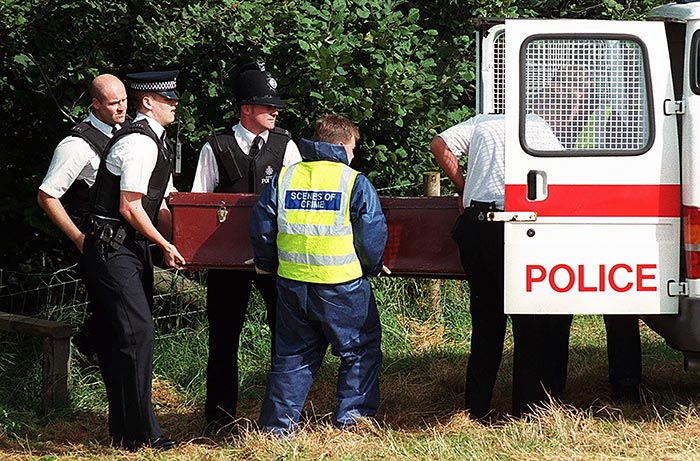 GRIM FIND... Police load a coffin containing the body of John Thompson into a van...