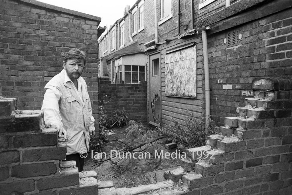 DECLINE... Concerned local resident Don Tapping points out some of the damage caused to empty properties by vandals on the Southside estate in Easington Colliery...