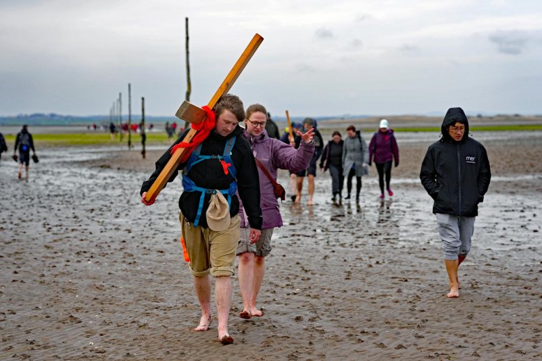 PILGRIMS' PROGRESS... Members of the annual Northern Cross pilgrimage arrive at the island of Lindisfarne after a week of trekking across the north of England...