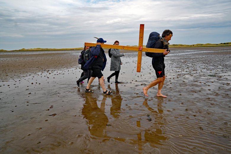 PILGRIMS' PROGRESS... Members of the annual Northern Cross pilgrimage arrive at the island of Lindisfarne after a week of trekking across the north of England...