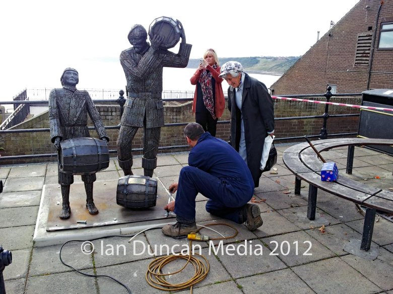 Artist Ray Lonsdale installs The Smuggler's Apprentice (Lesson 1) statue in Scarborough in North Yorkshire. Also pictured is local resident and philanthropist Maureen Robinson who bought the piece for the town. Photo: Ian Duncan.